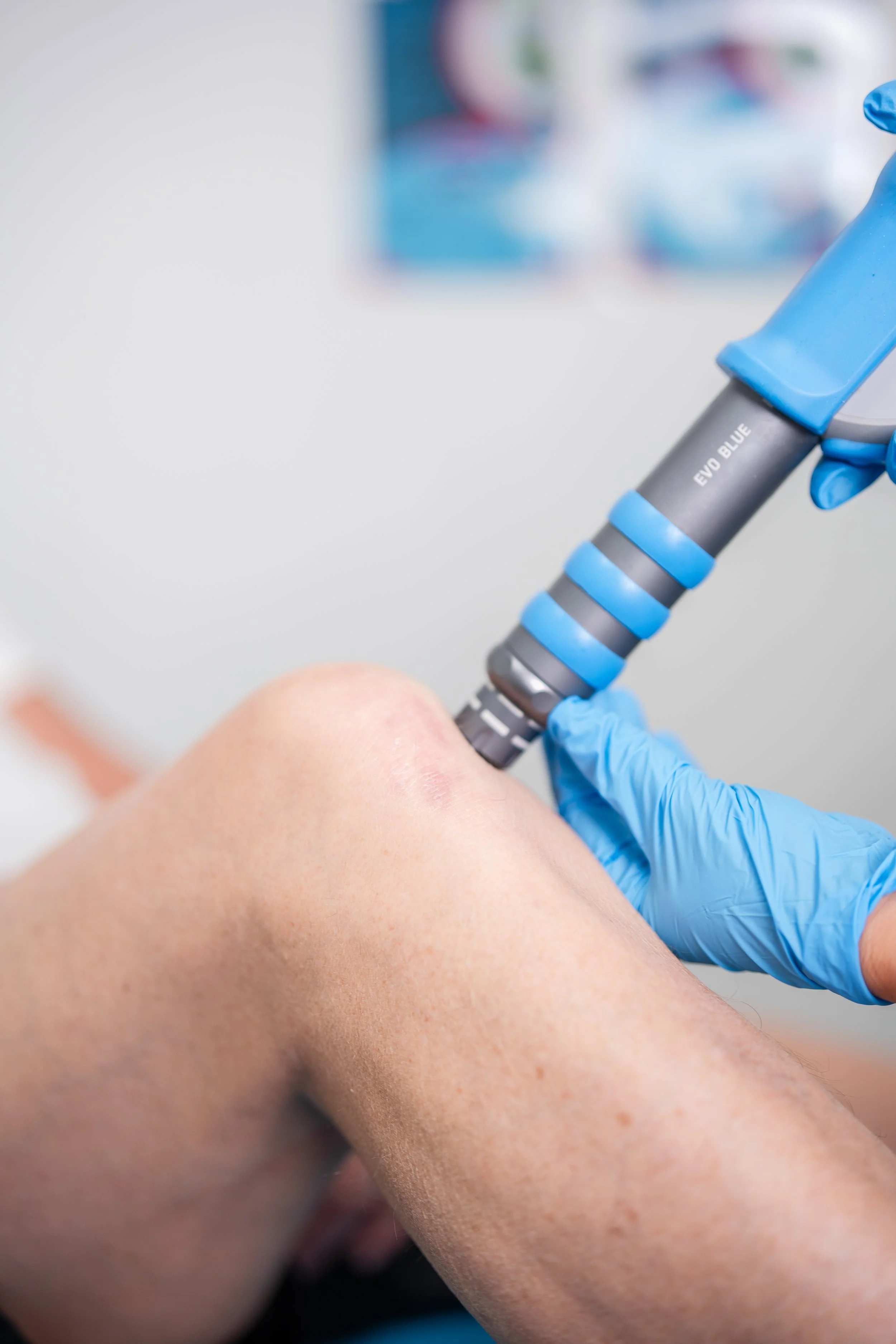 A person receiving an injection in their arm from a healthcare professional wearing gloves.