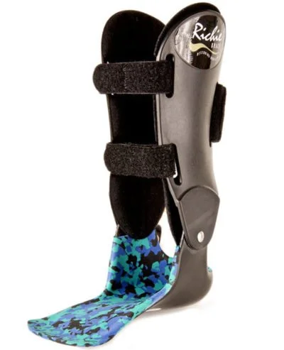 A leg brace with a blue camouflage-patterned fabric covering, black straps, and a rigid gray support structure, designed to stabilize and support the leg.