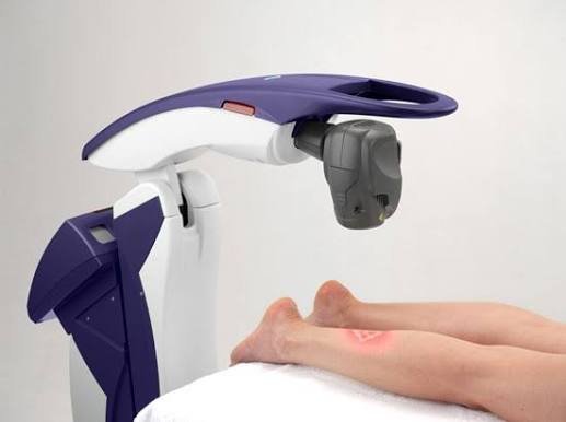 A laser scanner aimed at a person's finger, likely used for biometric fingerprint scanning or medical purposes.