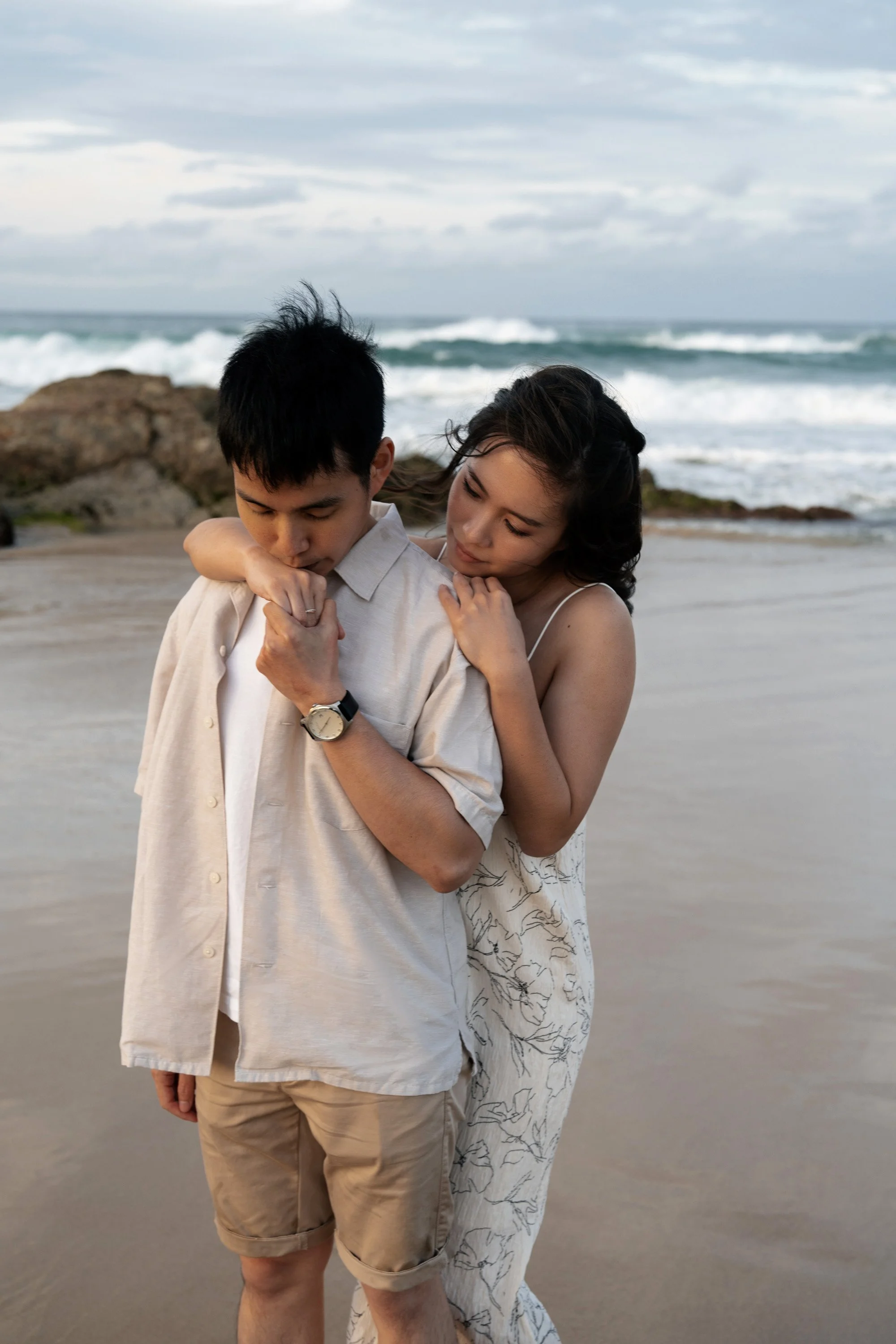 Paul kissing Krystel’s hand as she lovingly holds him from behind during their engagement shoot in Gold Coast. Captured in a tender and intimate moment, this Brisbane engagement photography beautifully showcases their connection and the romantic atmo