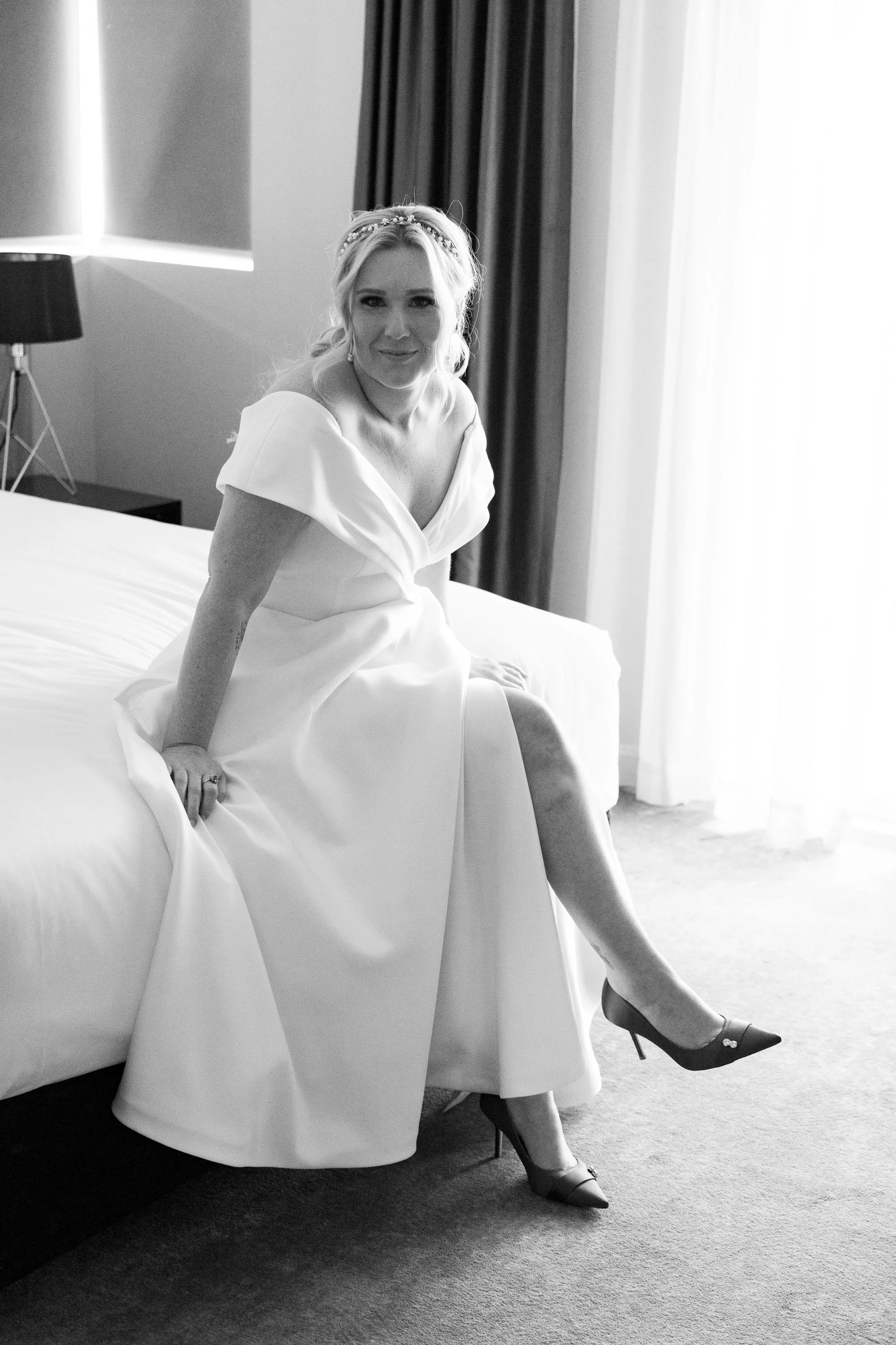 Bride Kyra looking at the Brisbane wedding photographer, captured in black and white, highlighting her expression and the timeless elegance of the moment