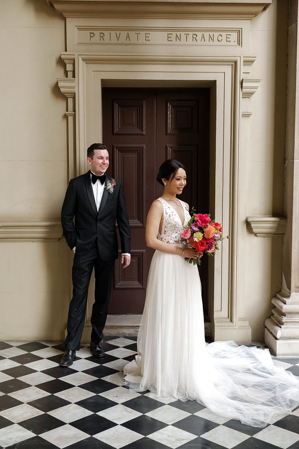 groom Cliffe stand 2 steps away behind bride Nori while look at her