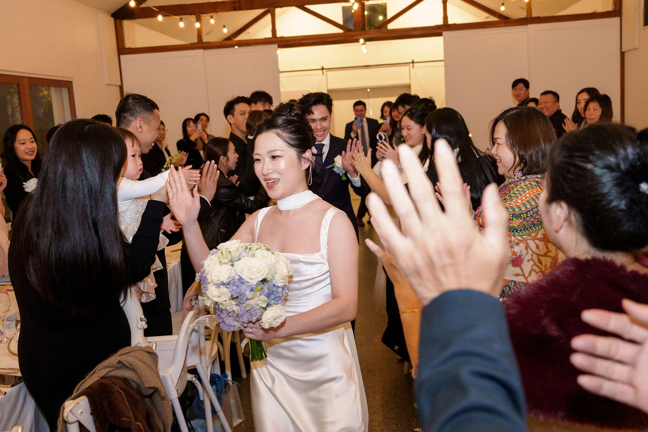 Lisa clapping to her family and friends when she walking to her reception room follow by Michael