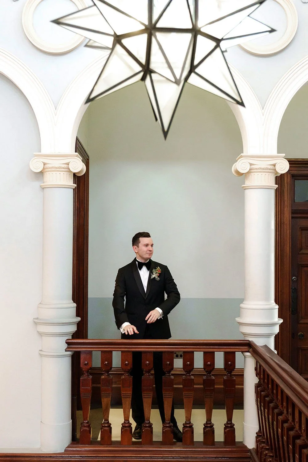 groom Cliffe hands on the rail and look to his groomsmen