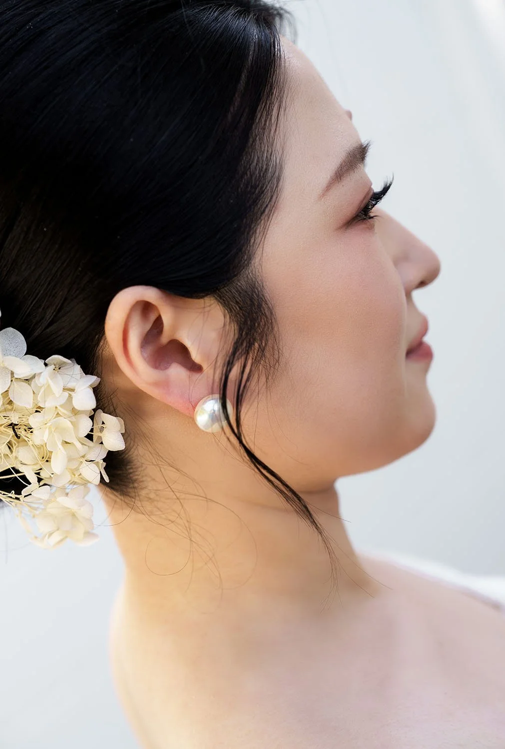 Lisa's peal earring on her ear, and her hair decor too