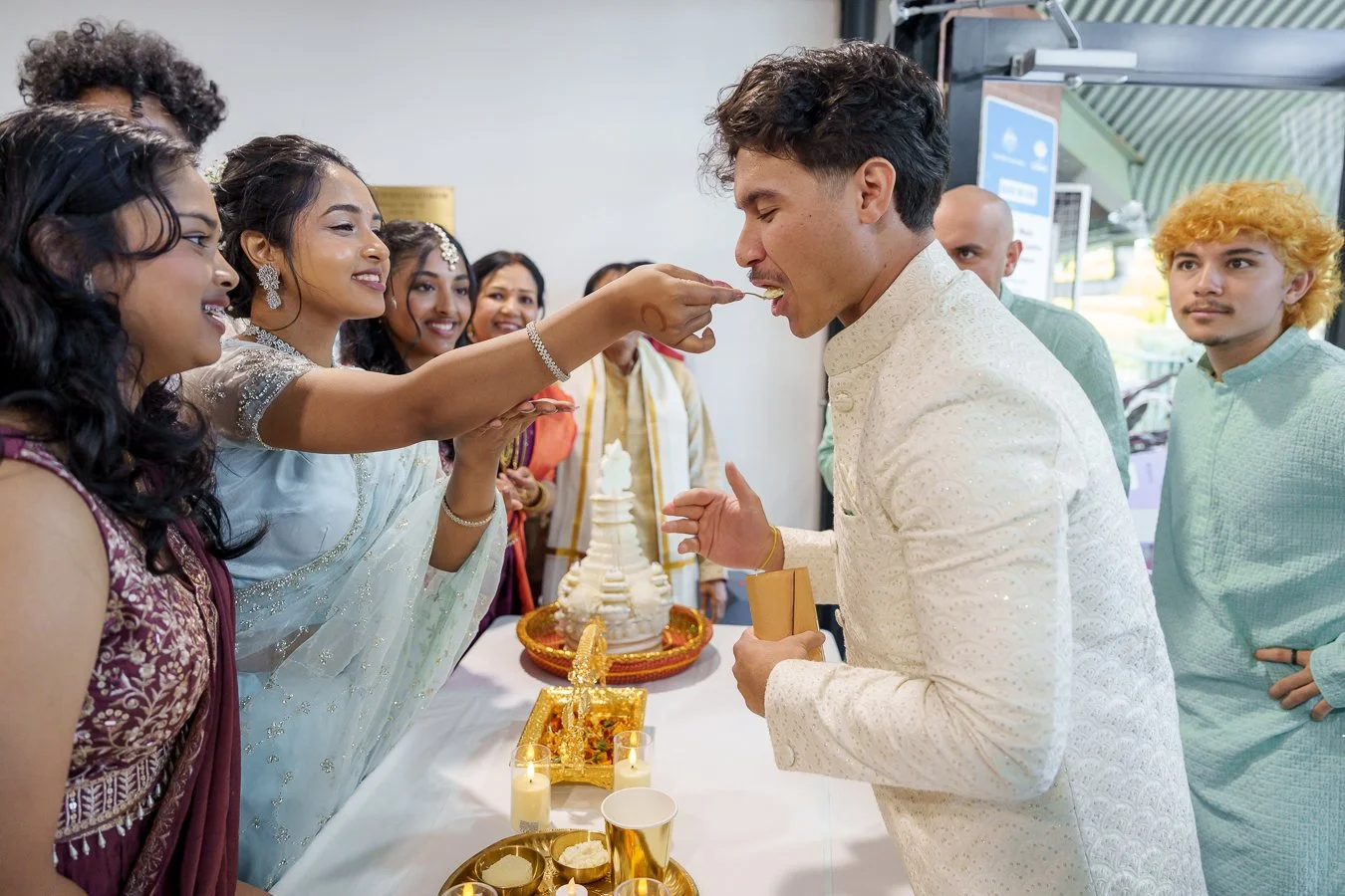Amrita's girlfriend feeding a spoon of rice to Casey