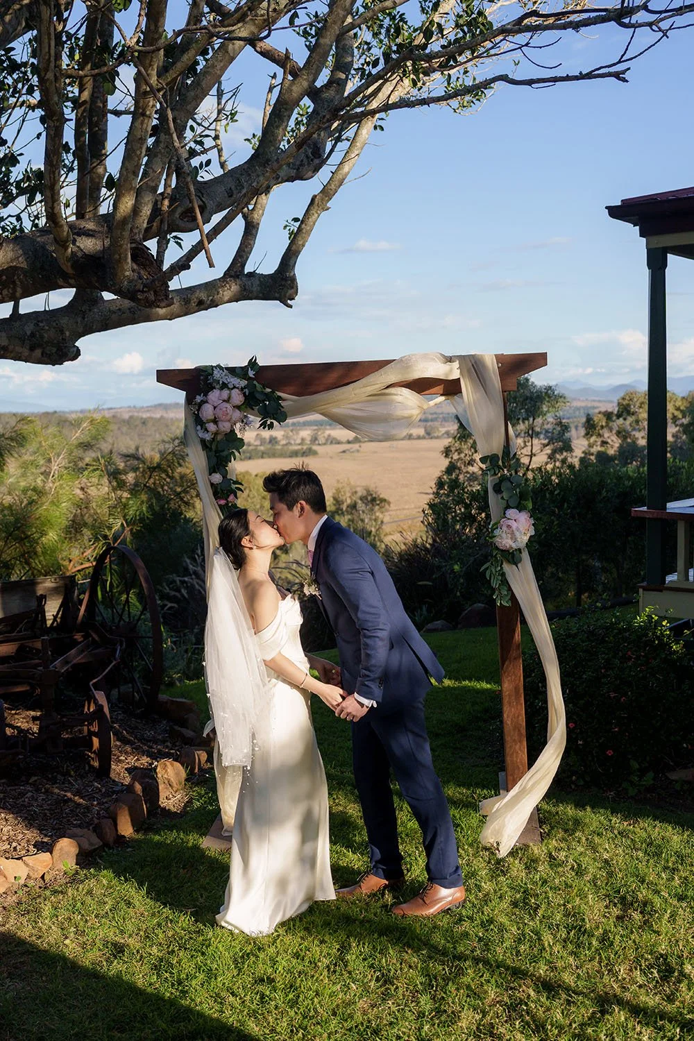 Flora and Eric is kissing under arch