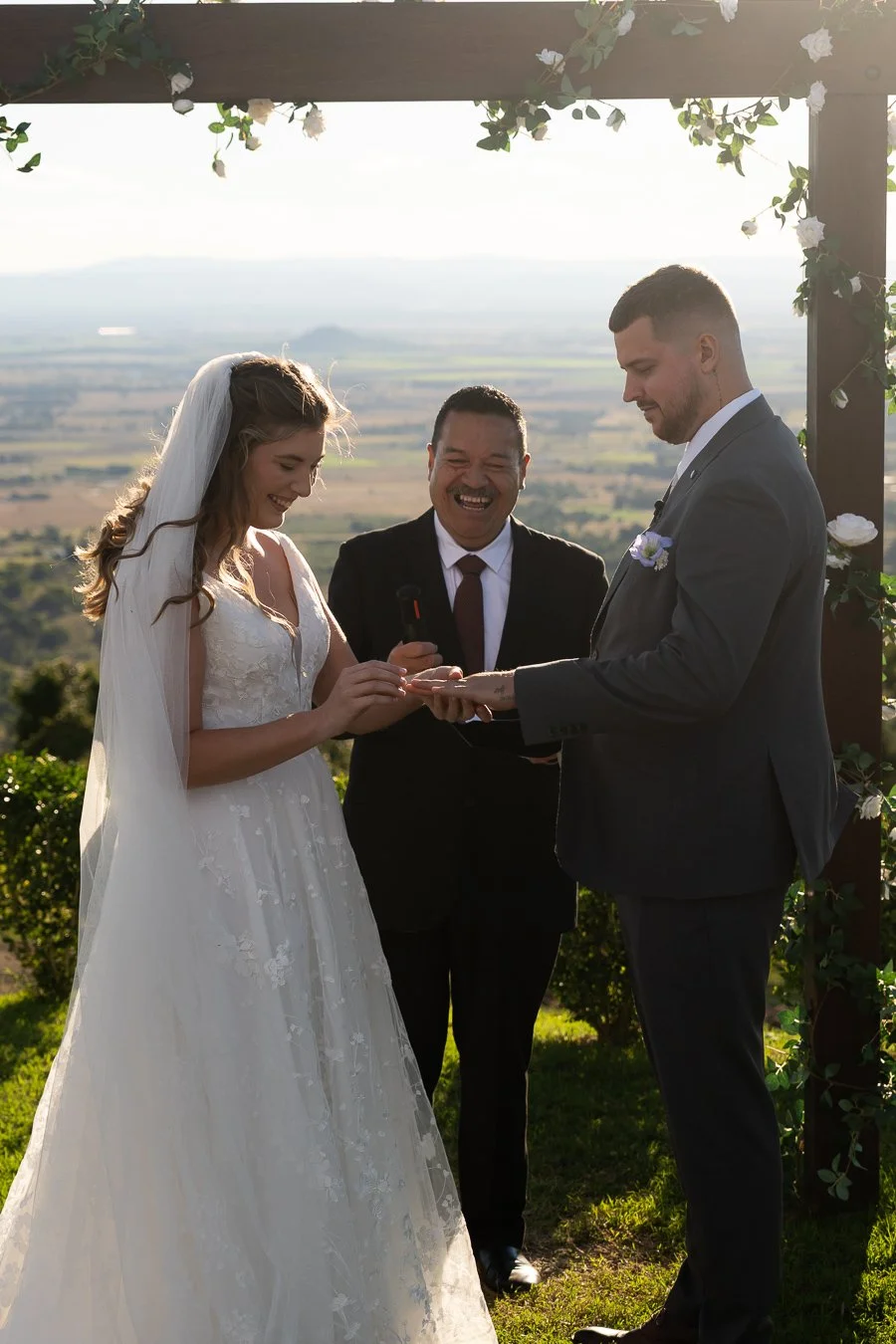bride Chiarra put on the wedding ring for groom Ben with laughing