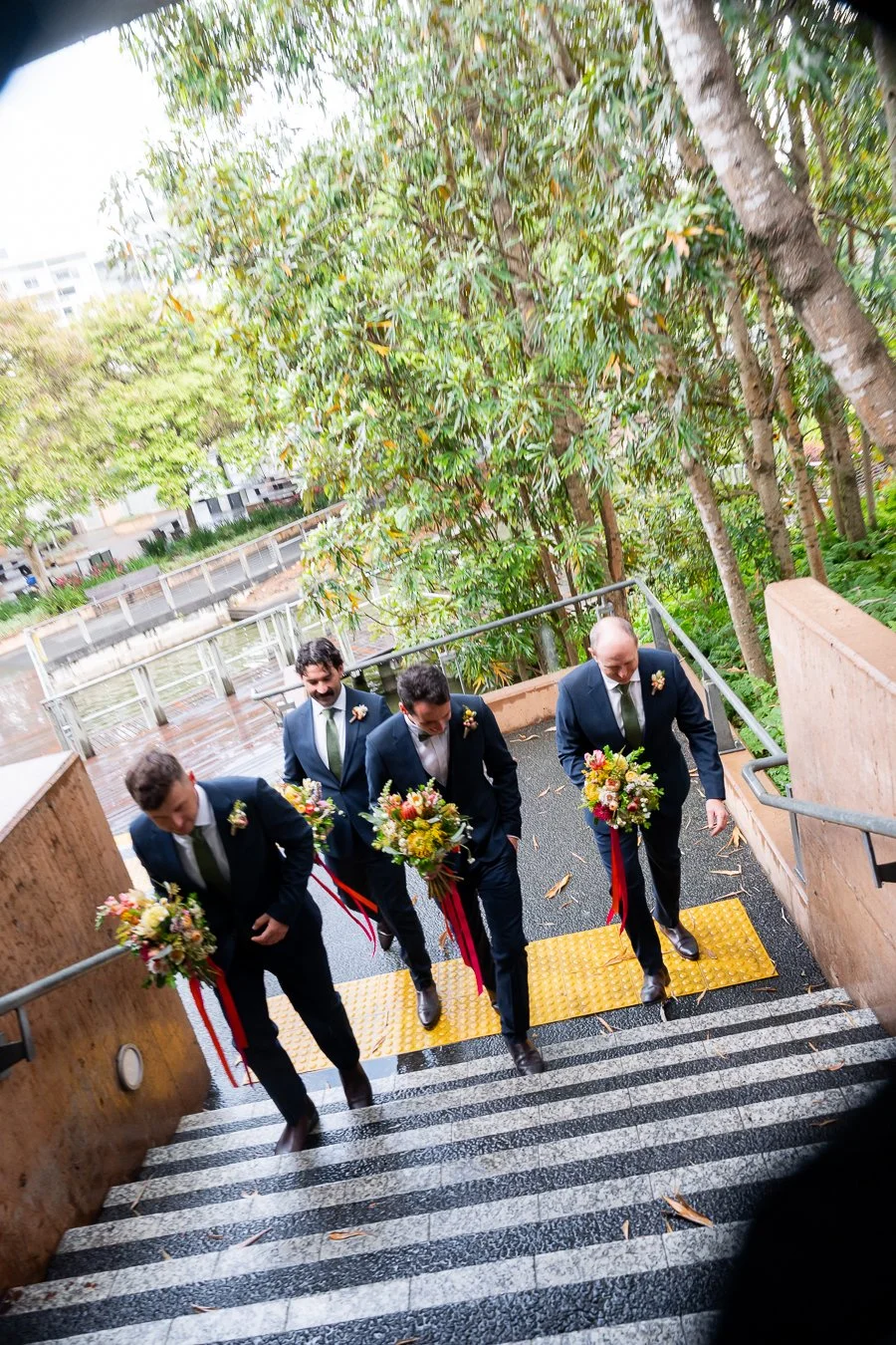 groom Giordan leading his groomsman walking up to the stairs