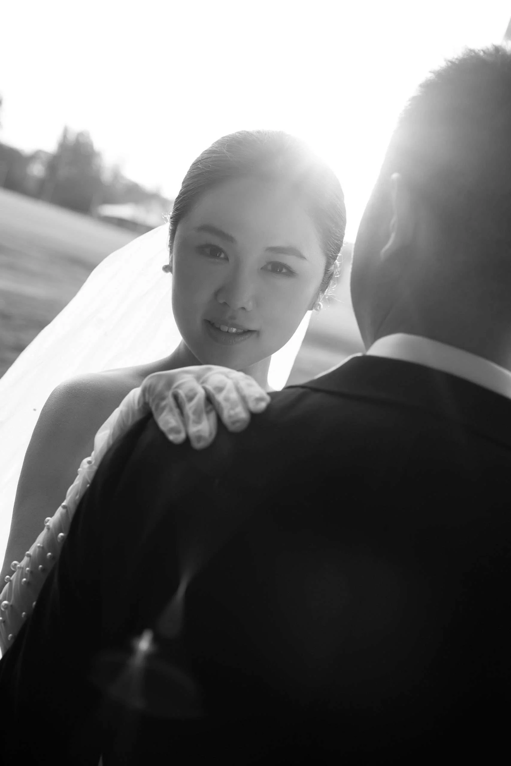bride Wendy look at the Brisbane wedding photographer Whistler Li and sun shining through her head