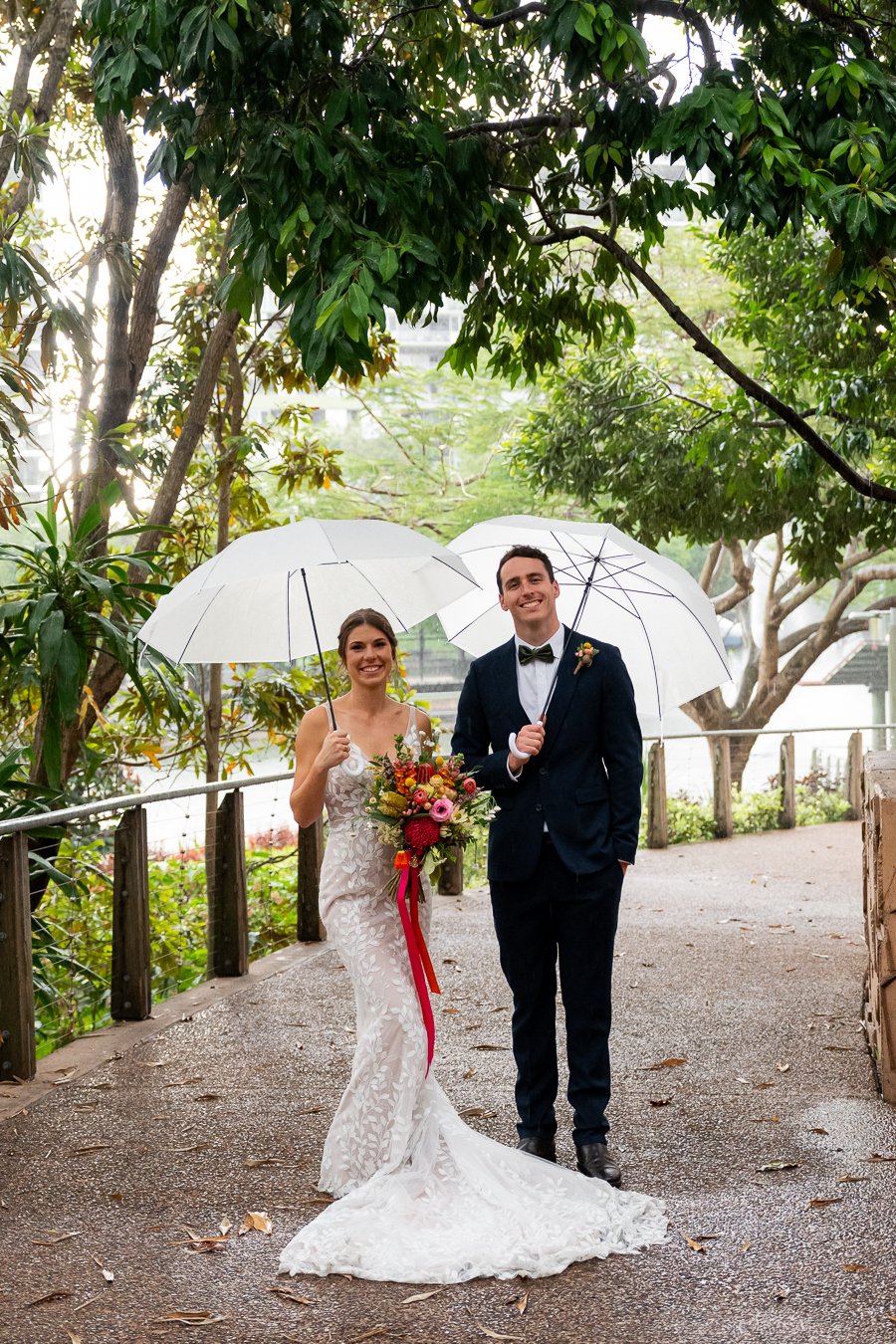 Bride Sonya and groom Giordan holding umbrella smell to the Brisbane wedding photographer Whistler when they stand side by side