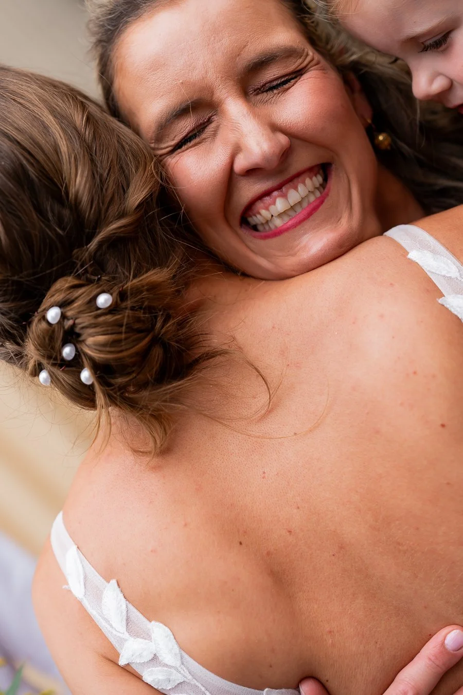 a female girl hugging bride showing her loving face to the camera