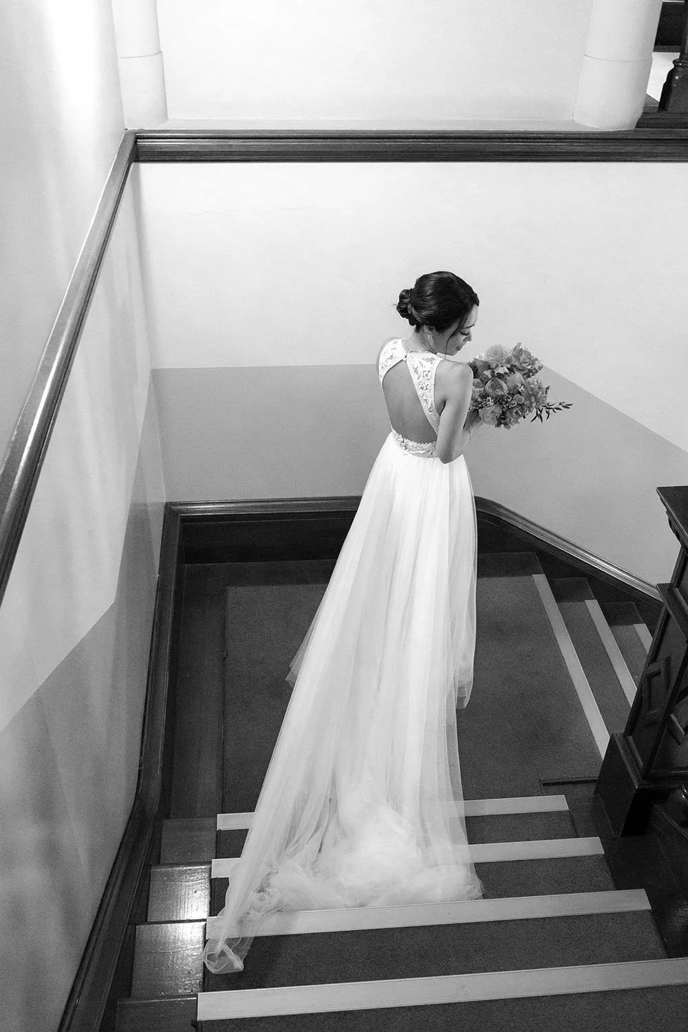 Bride Nori walking down the stairs while look at her right shoulder