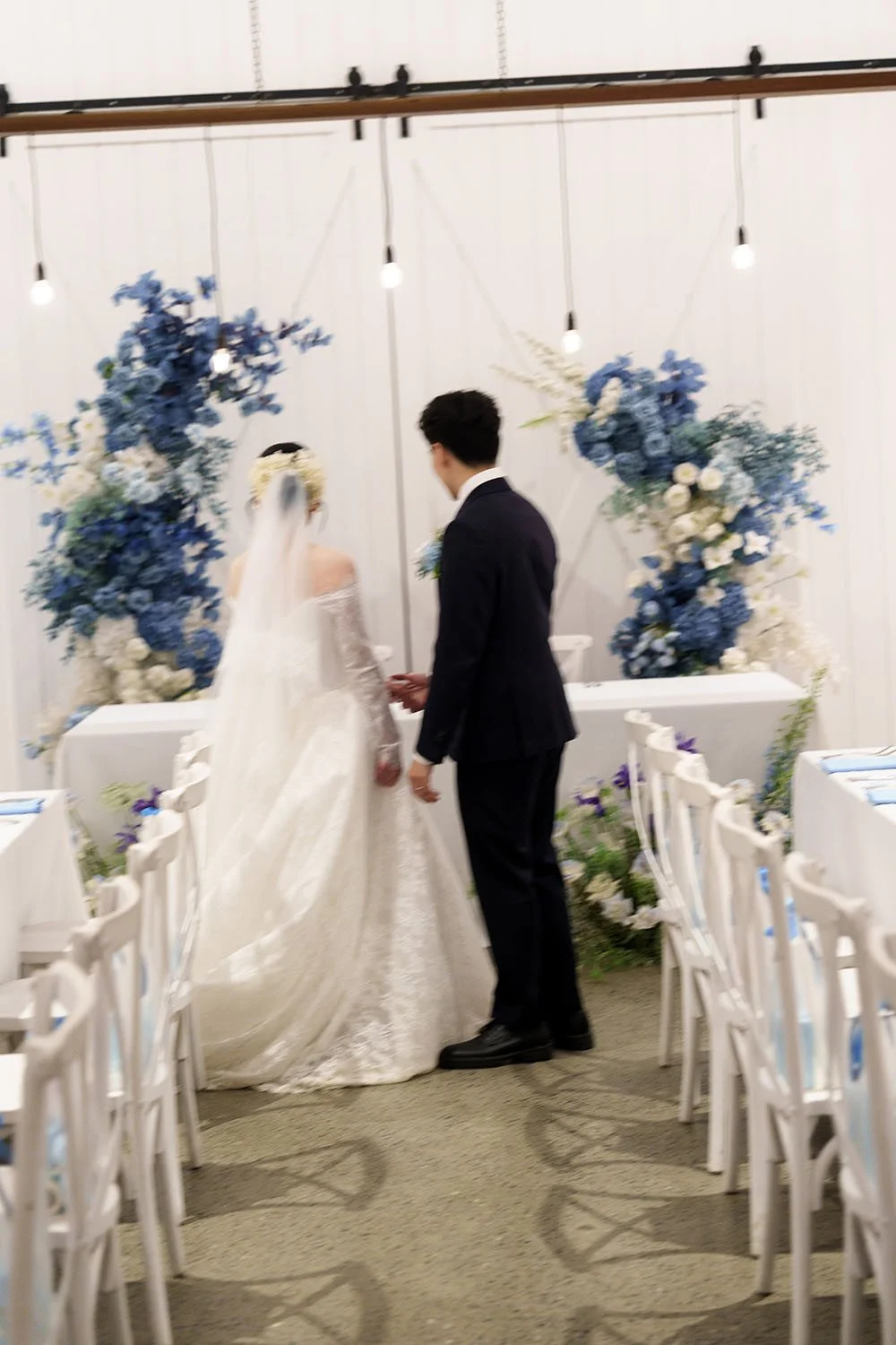 Lisa and Michael look to their bridal table with hands joints