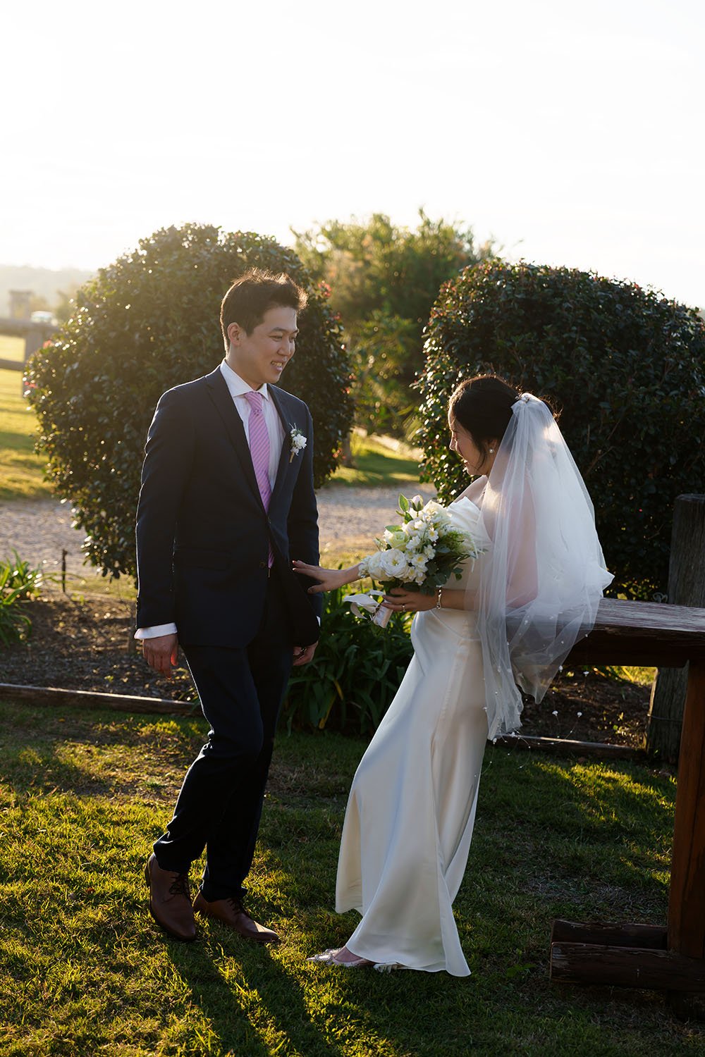 Eric smell walking towards to Flora and Flora look to his suit with smell too, sun light behind them
