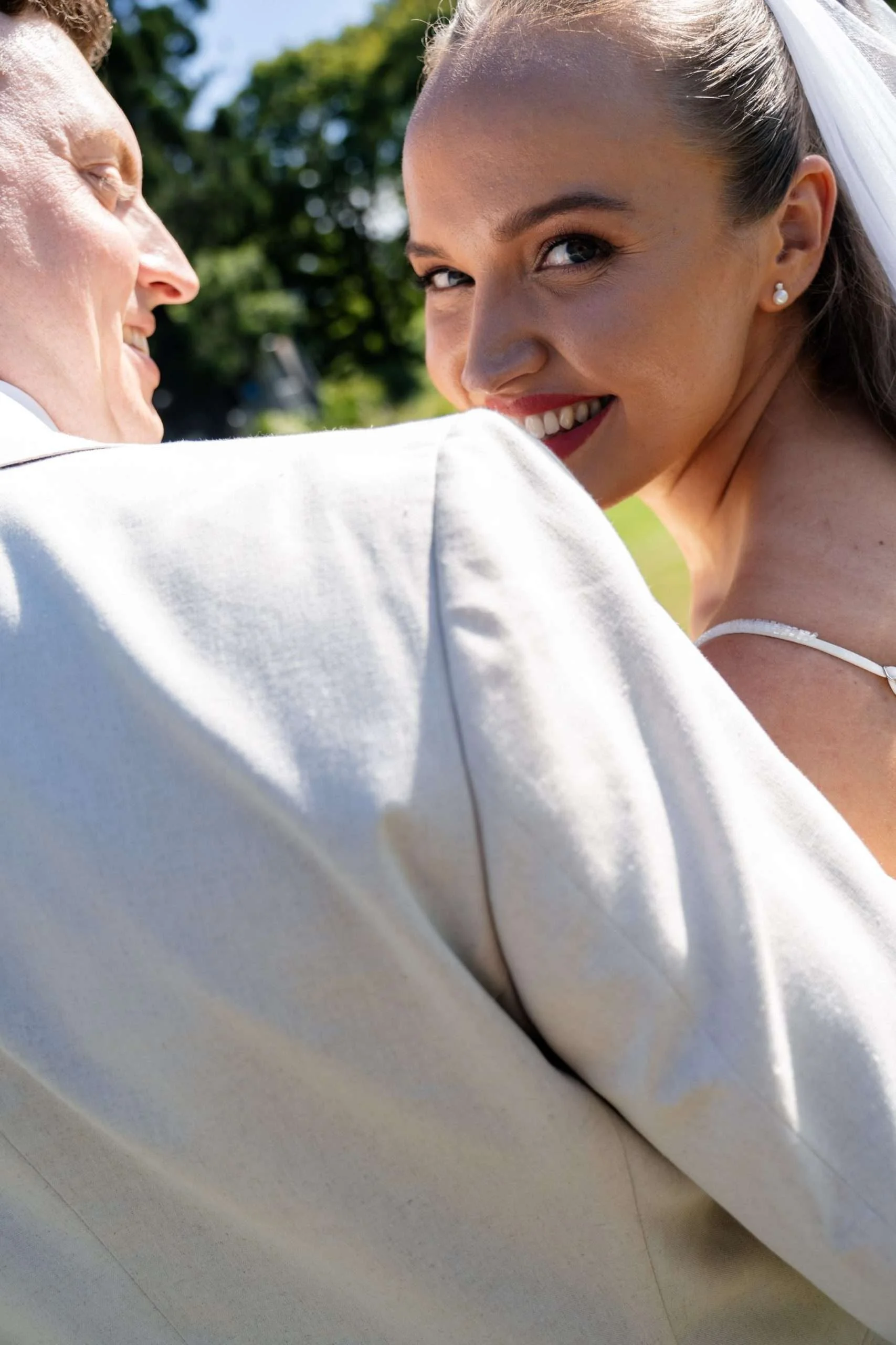 bride Charlotte look back to the camera while groom Jack look at her