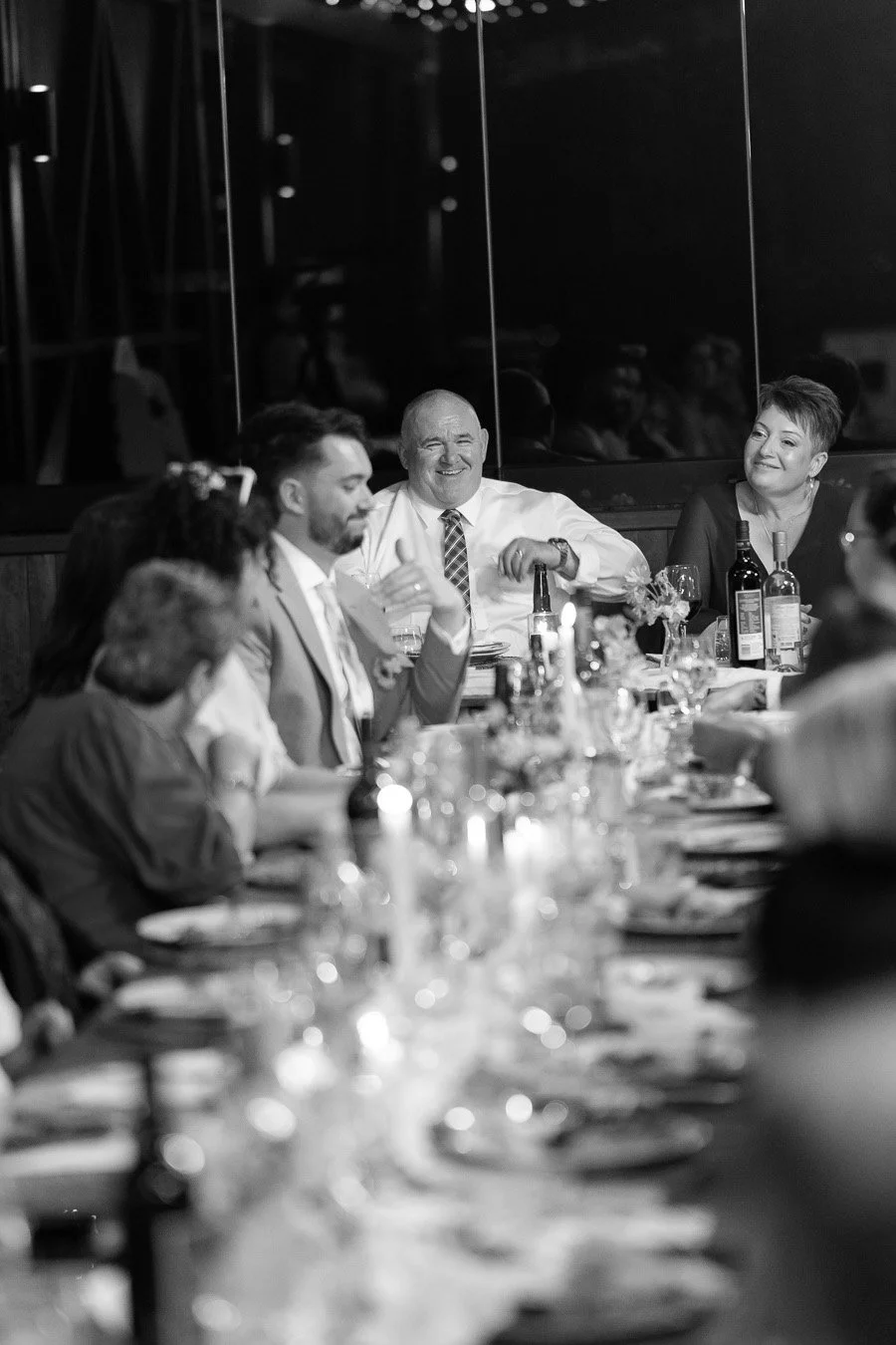 bride Chiarra's brother sitting in front of the dinning table made a game over hand gesture make his parents laughing