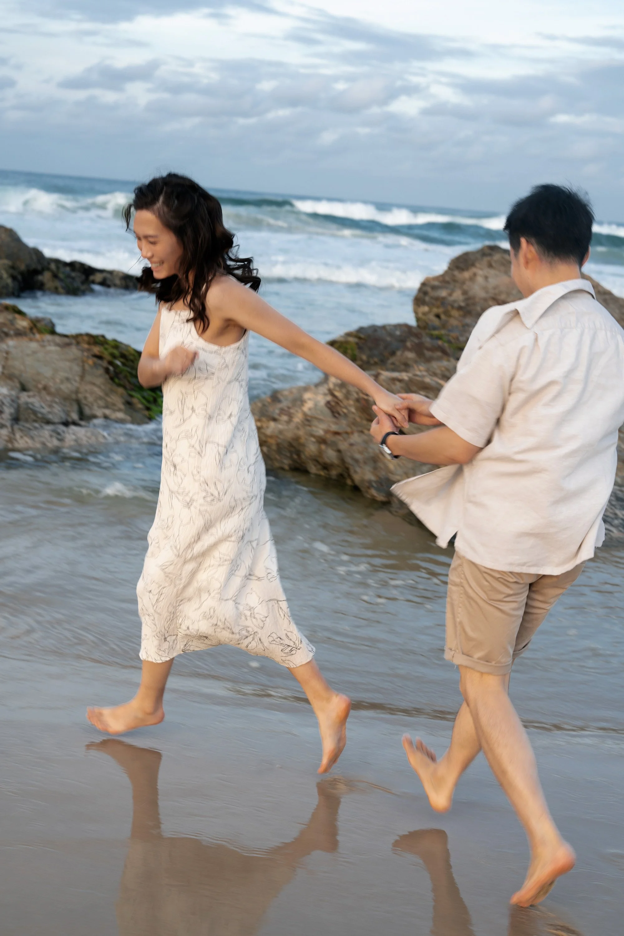 Krystel holding Paul's hands running on the beach in Gold Coast