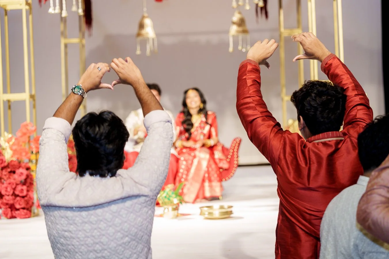 two guests doing a heart gesture to Amrita and Casey