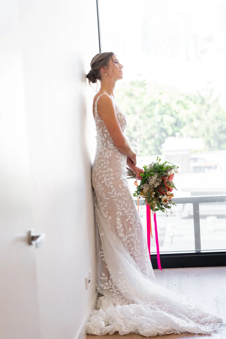 The bride stood against the wall, looking ahead.