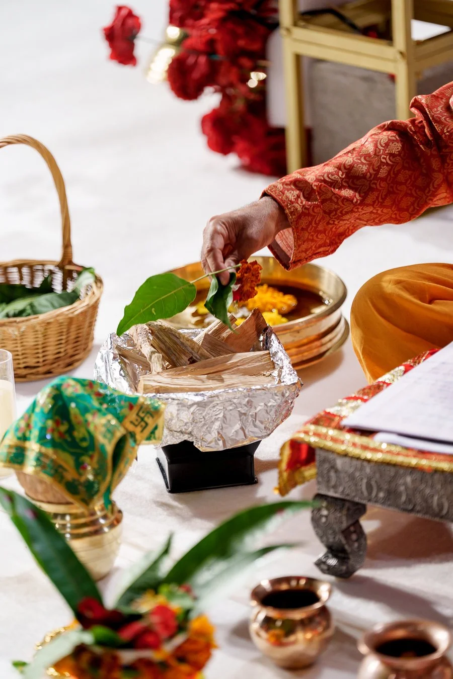 priest put a flower and green leaf into a box