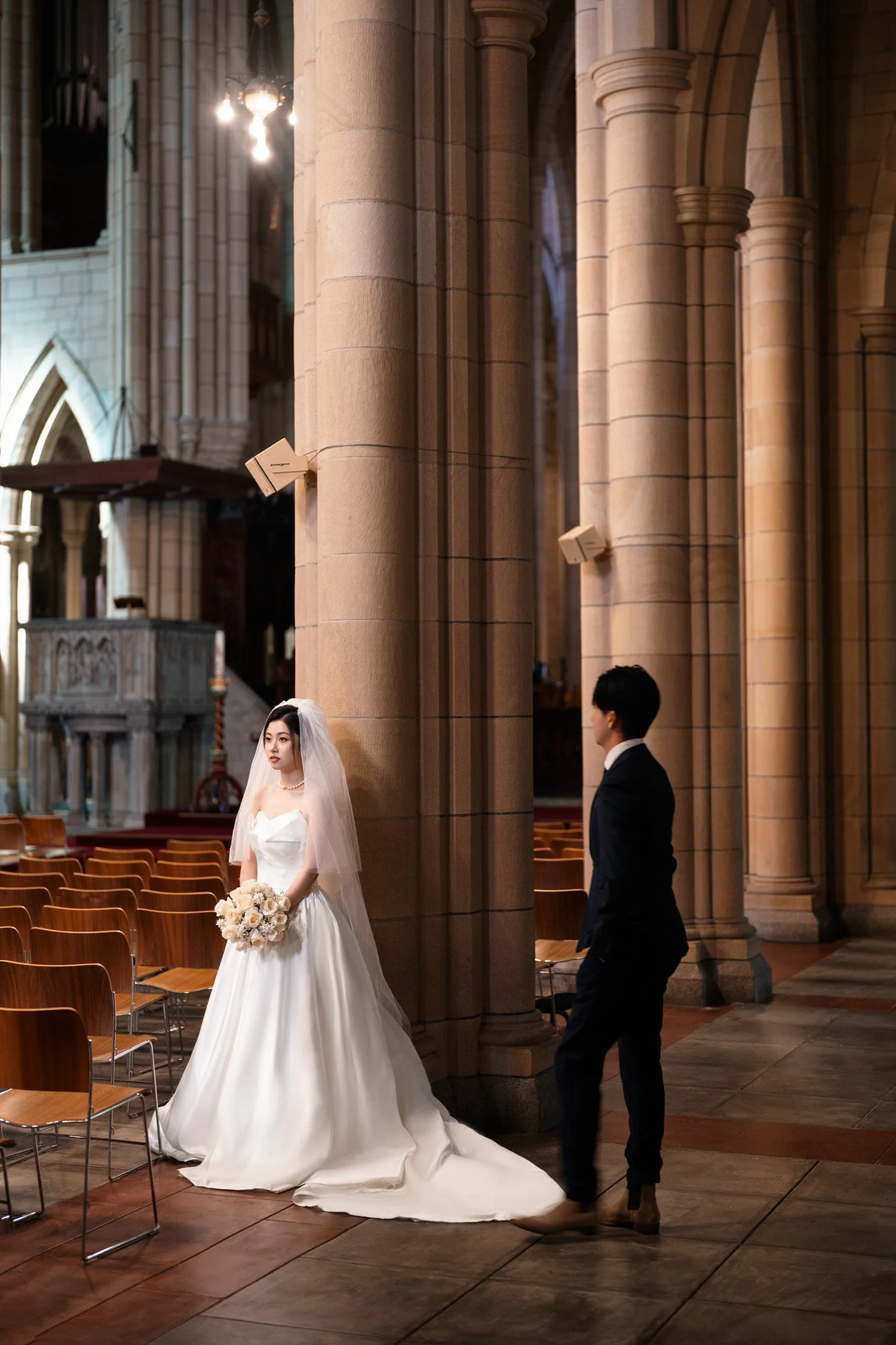 bride standing there and groom walking towards to her in St John's Cathedral in Brisbane