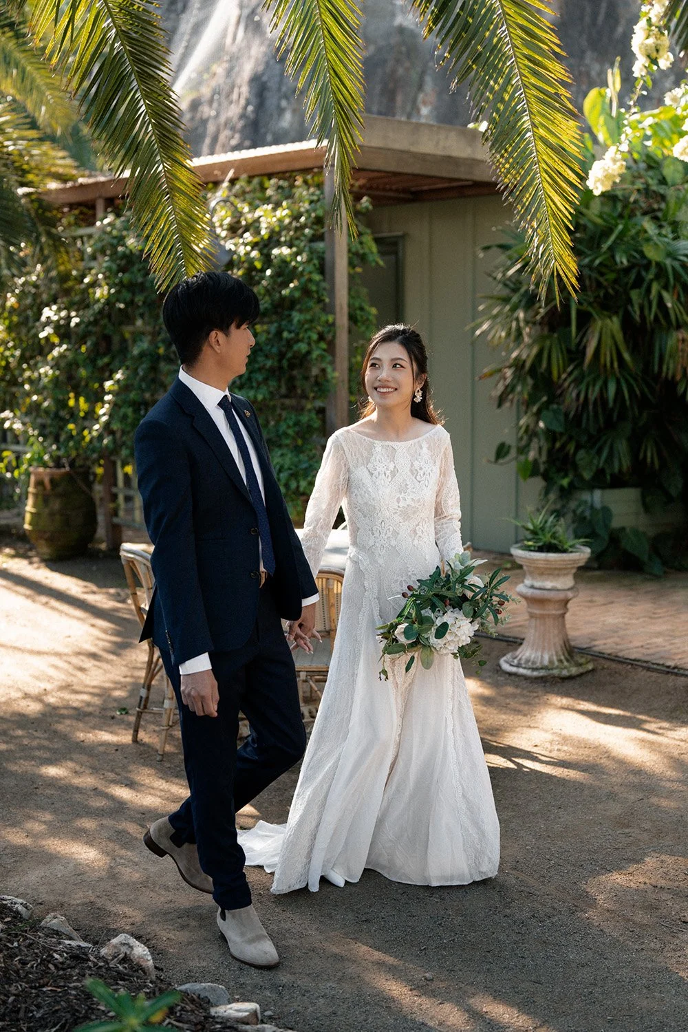 bride and groom holding hands walking and bride Cassie look at Leo in Wilson Outlook Reserve