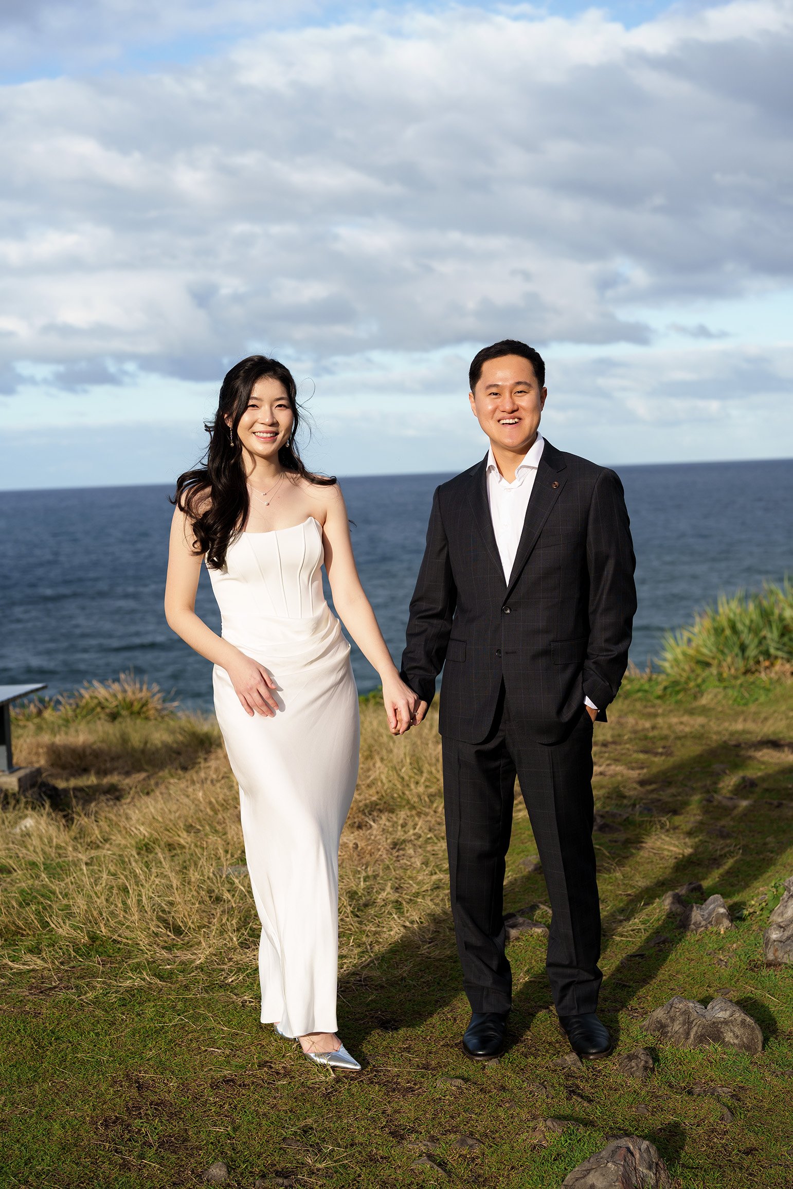 Margaret and Silva hands holding look at the Brisbane wedding photographer Whistler Li with paint light on their face