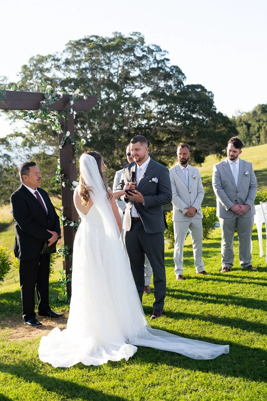 Ben look at bride Chiarra with a smell and his groomsmen stand behind them watching