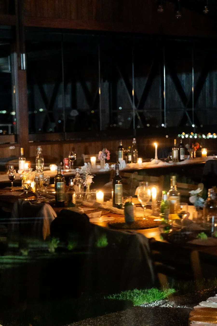 reception tables through window see candles, wine bottles