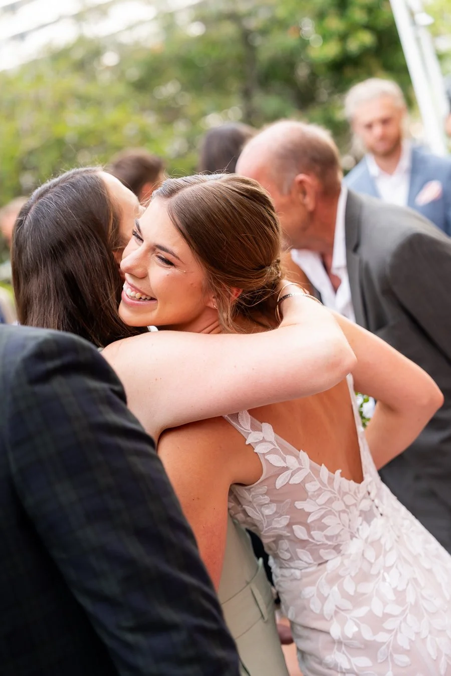 bride Sonya hugging a guest after ceremony outside St Mary's Catholic Church