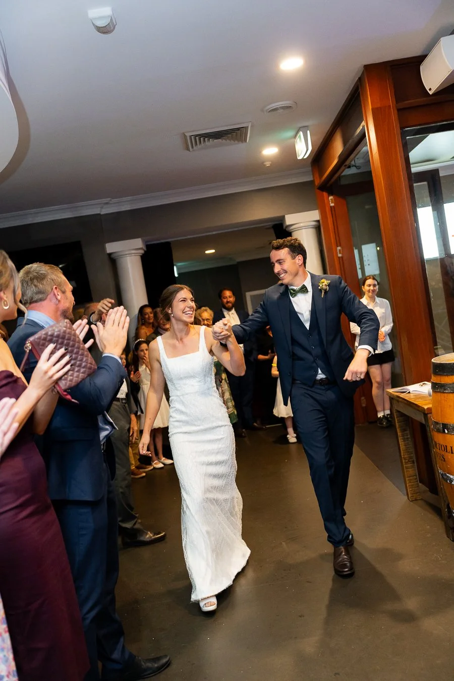 bride and groom walking into the reception with all guests cheers