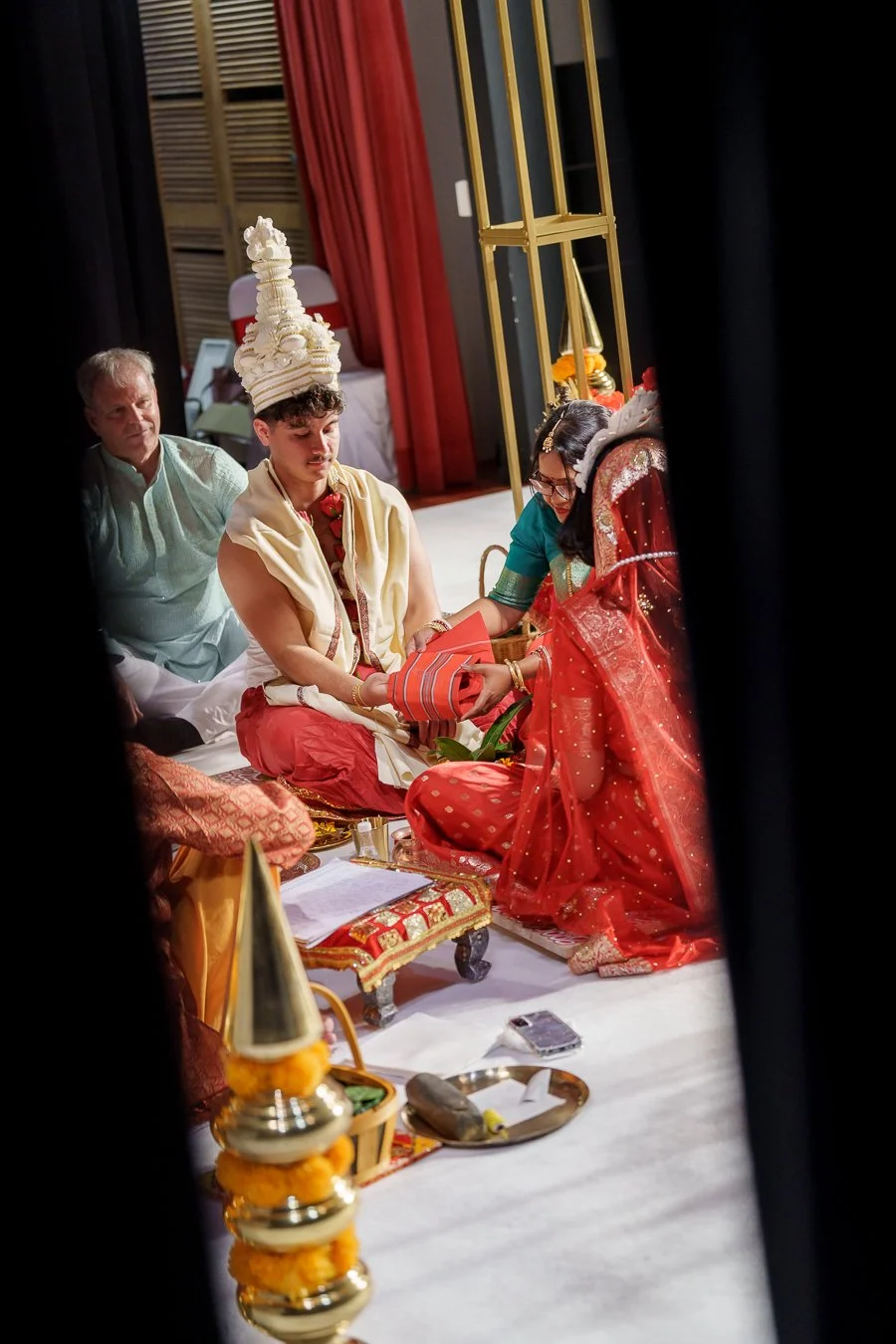 Casey look to the red cloth that wraps his and Amrita's hand