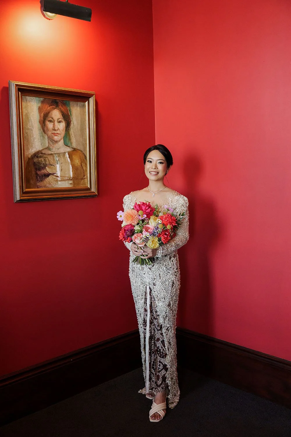 bride Nori smell to the camera while two hands holding her flower