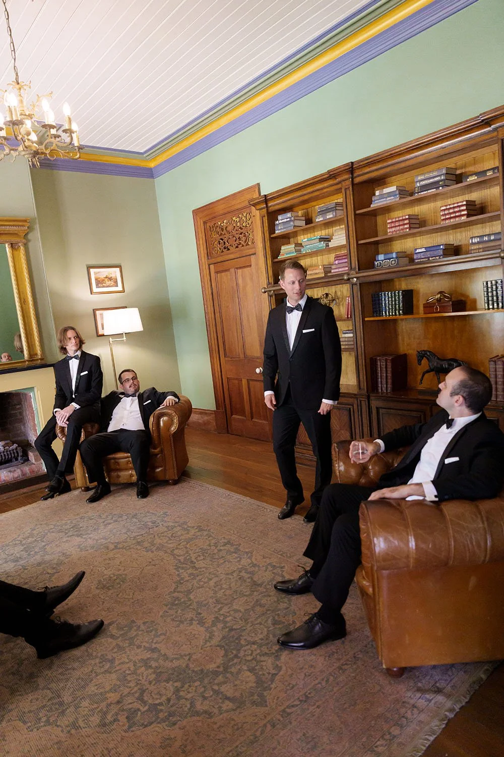 Morgan stand in the middle of the Gabbinbar library room talking to his groomsman