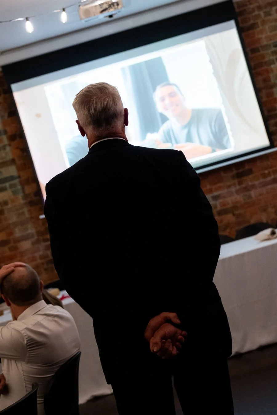 Giordan's face hands at back and look at Giordan's photo in screen