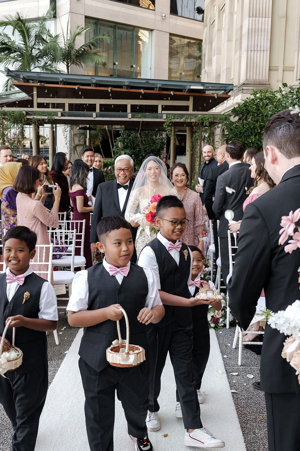 The other page boy hands the wedding rings over to the groom