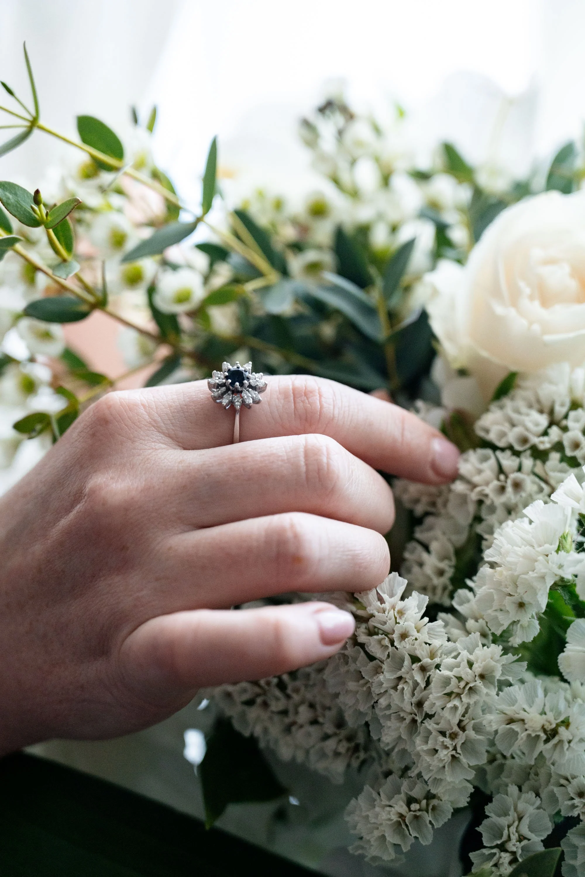 A black wedding ring paired with a delicate flower, symbolizing a unique and elegant blend of style and nature
