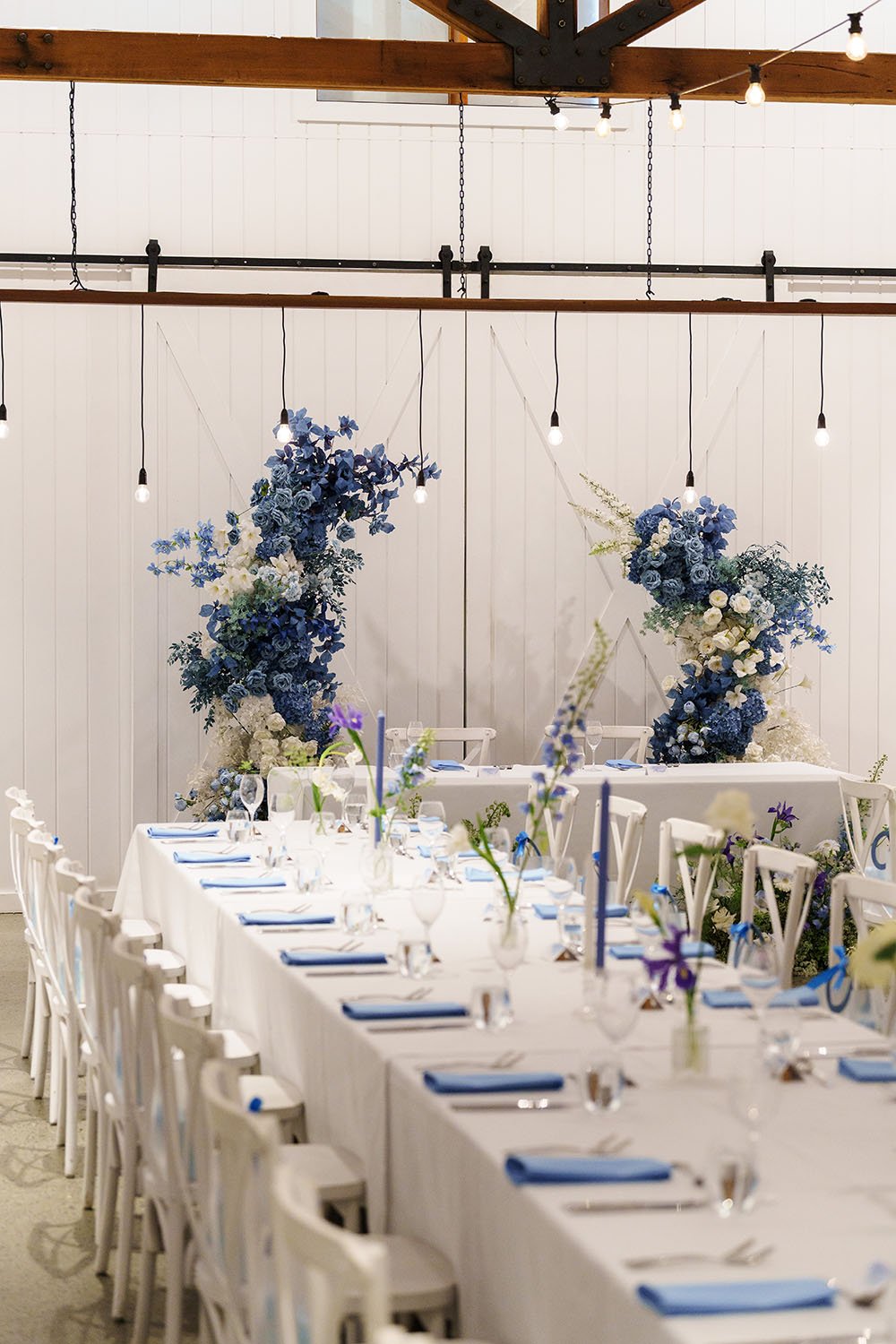 white table, blue handkerchief folding on the table, blue kindle and purple  flower