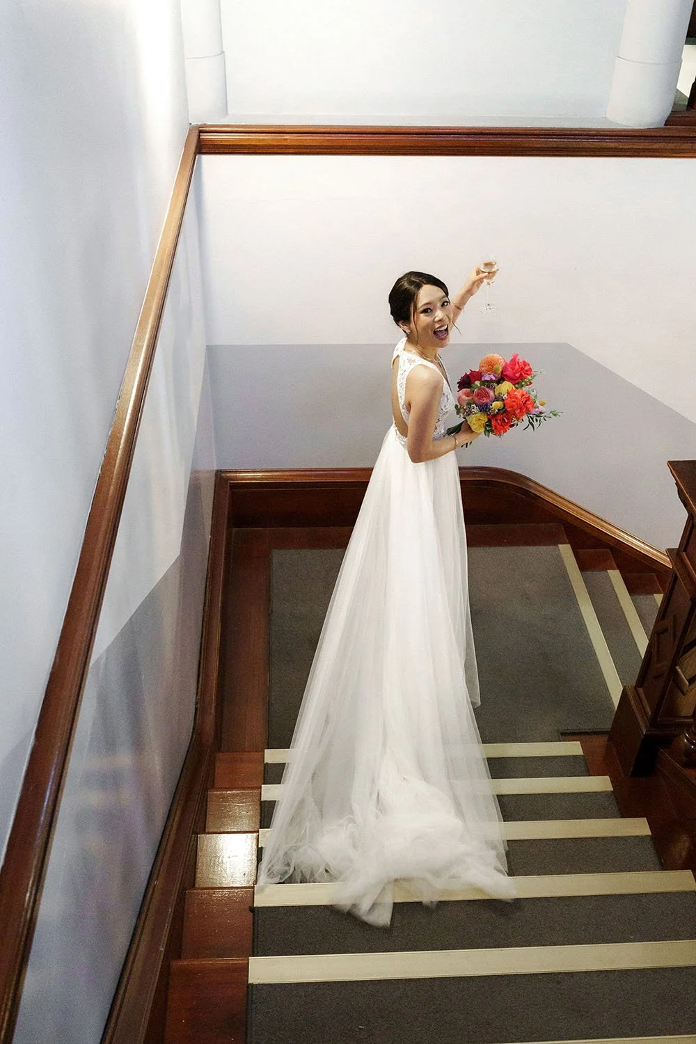 bride Nori raising her glass of champing to Brisbane wedding photographer Whistler Li