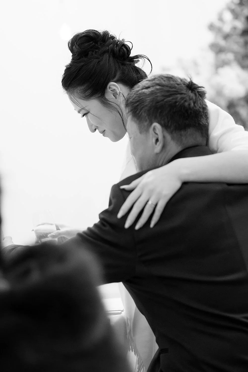 Lisa holding a drink hugging her dad