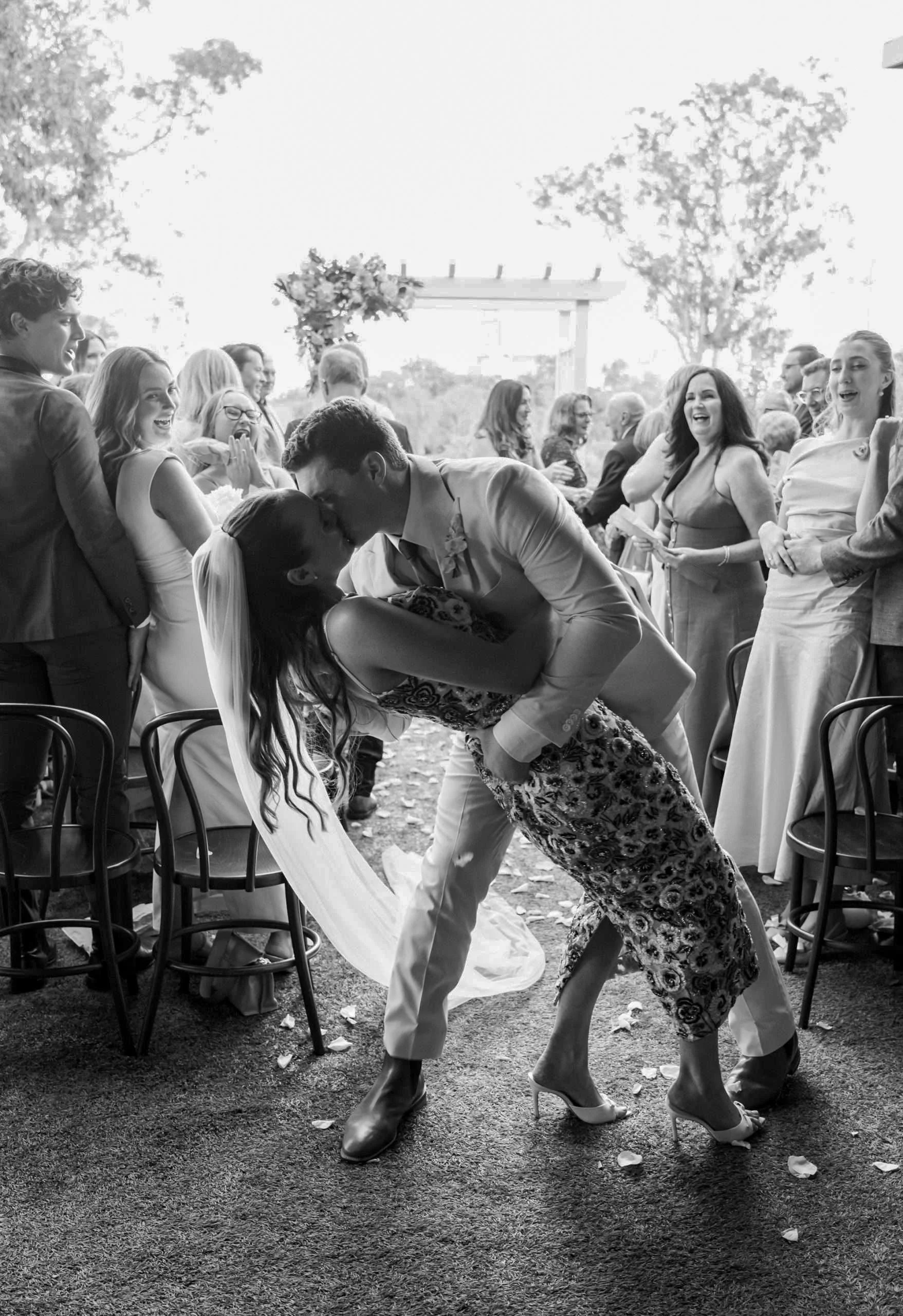 Jack is dipping kiss Charlotte after their wedding ceremony and all guests cheers for them