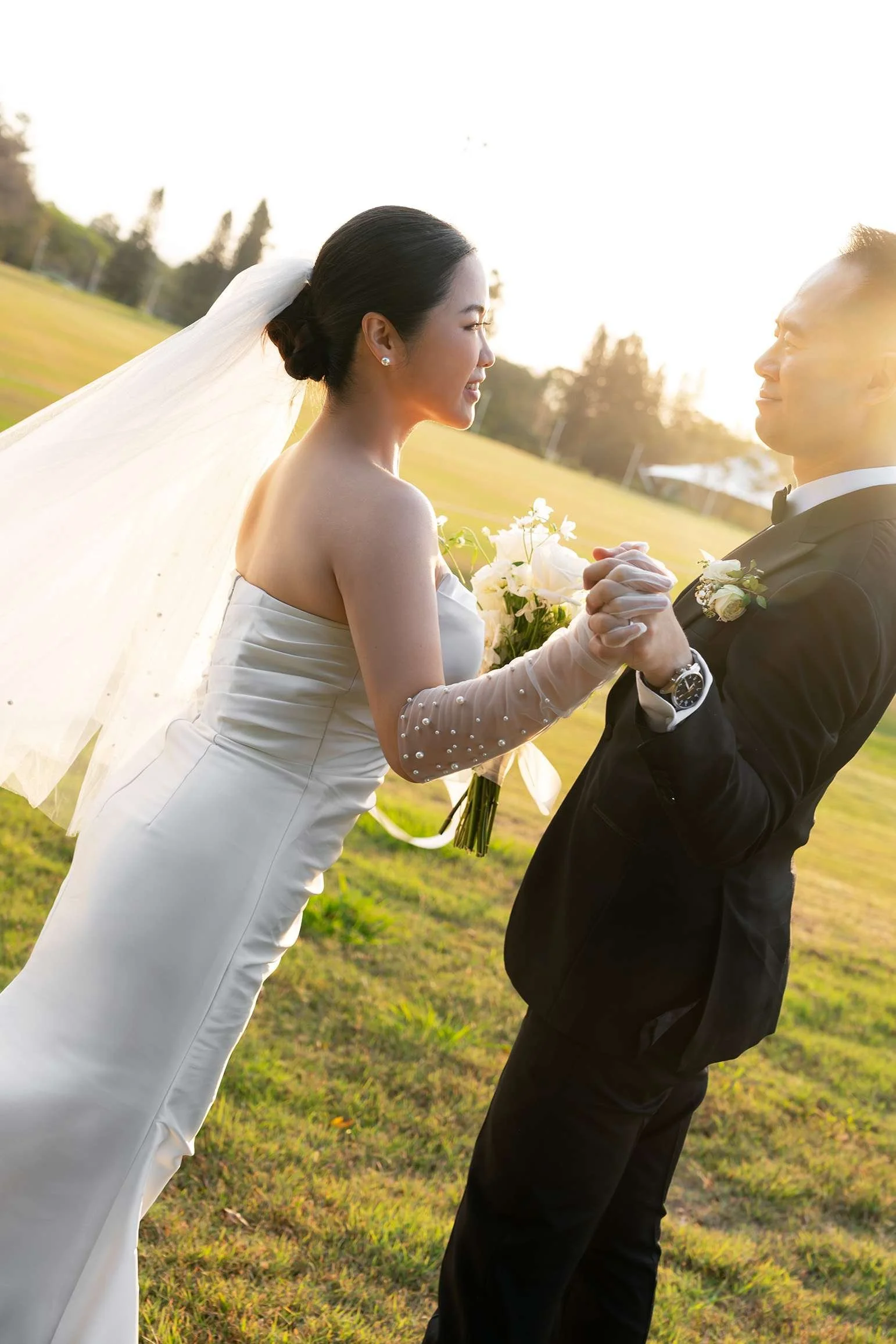 Wendy and Alex look at teach other's eyes while hand holding under sunset