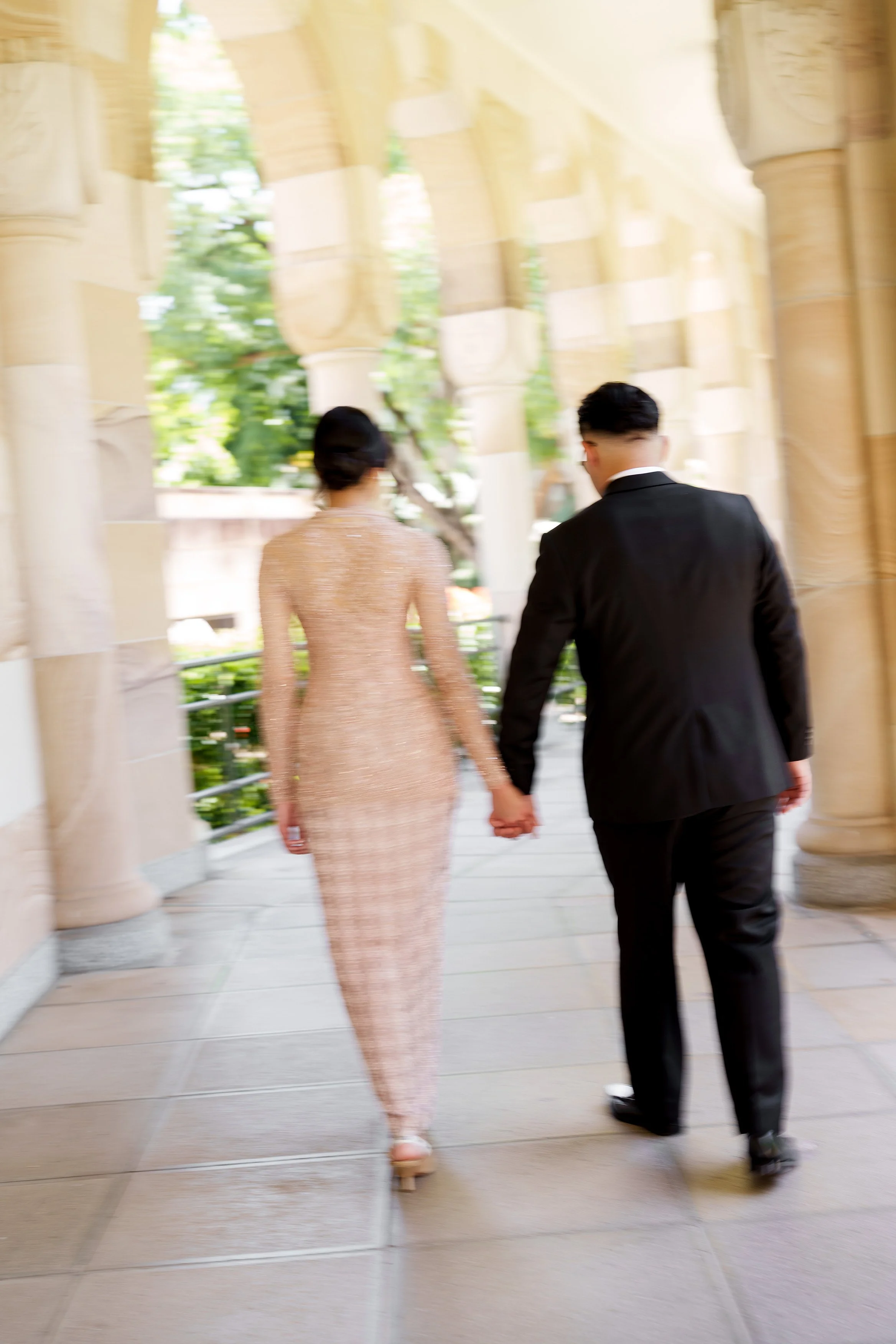 Bella and Aka hands holding walking away from the Brisbane wedding photographer Whistler Li