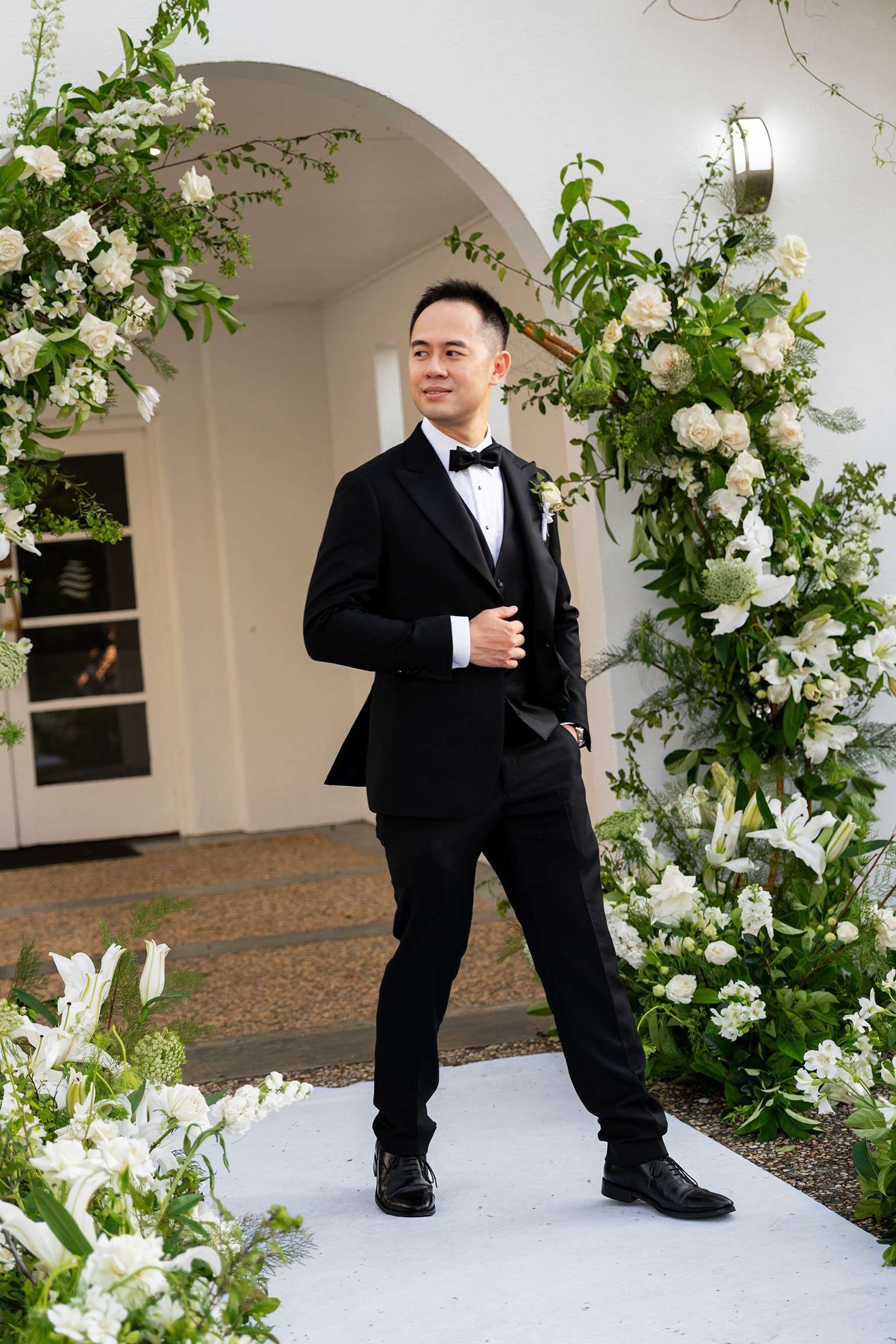 groom Alex one hand holding his jacket look away from the camera