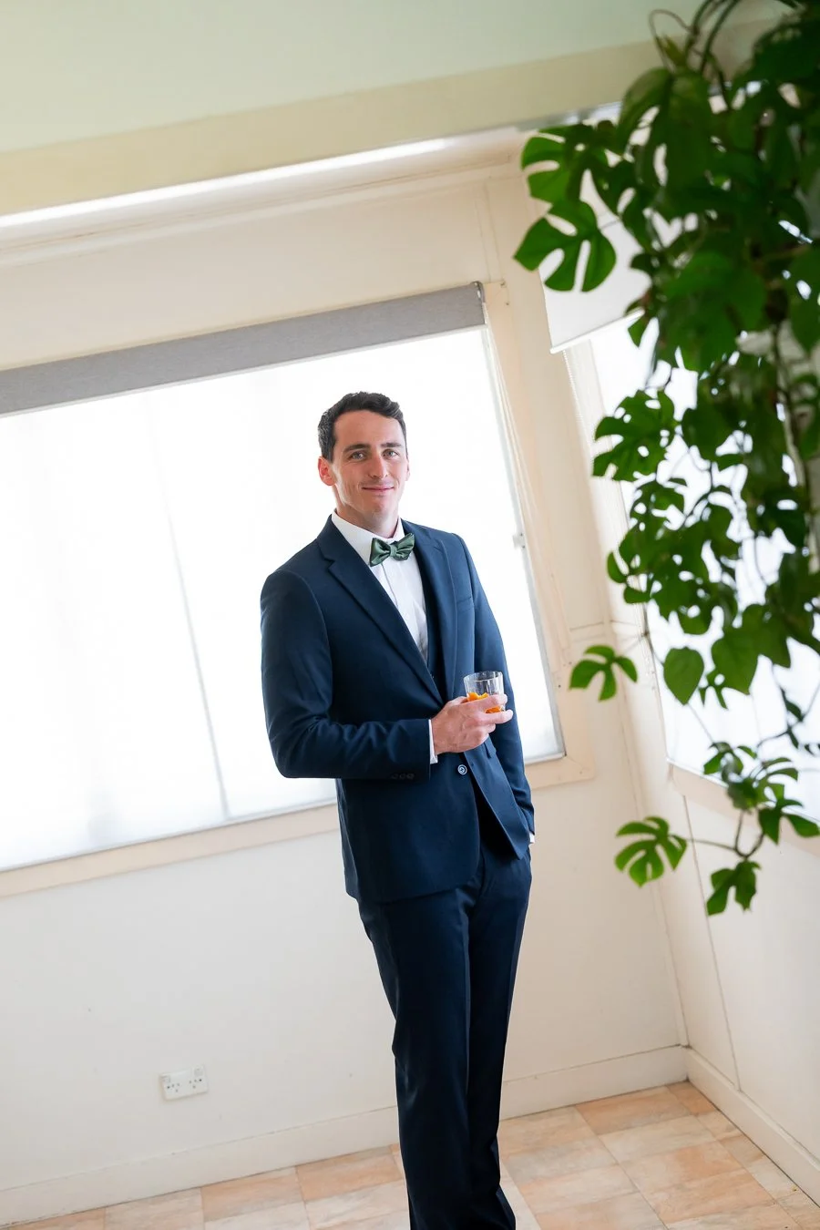 The groom stood by the window, looking at the camera
