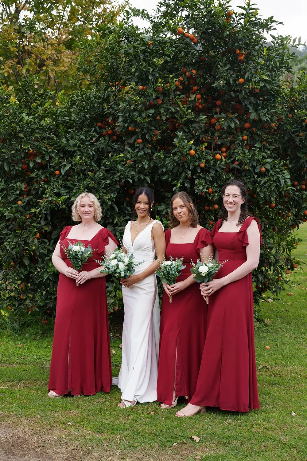 bride with her 3 brides mates holding flower in same level and look at the Brisbane wedding photographer Whistler Li