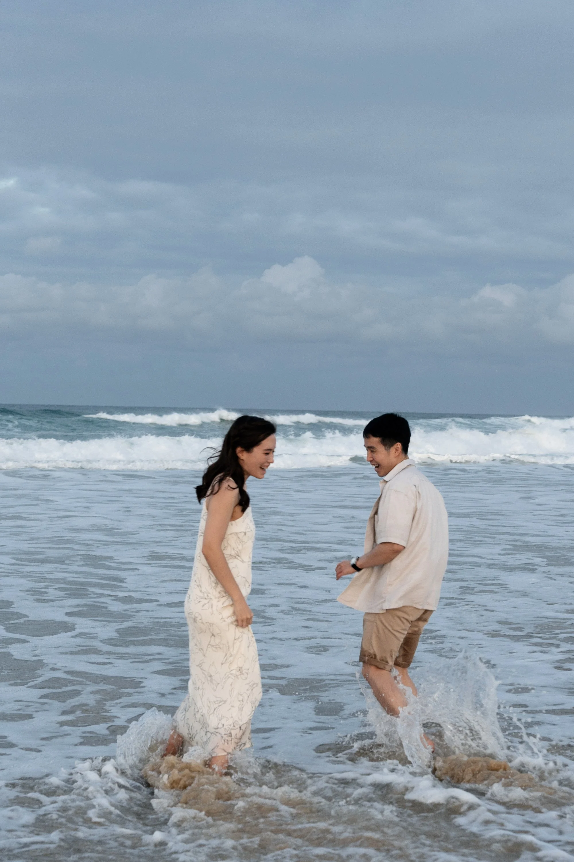 Paul and Krystel running around each other and step water, Brisbane engagement photography