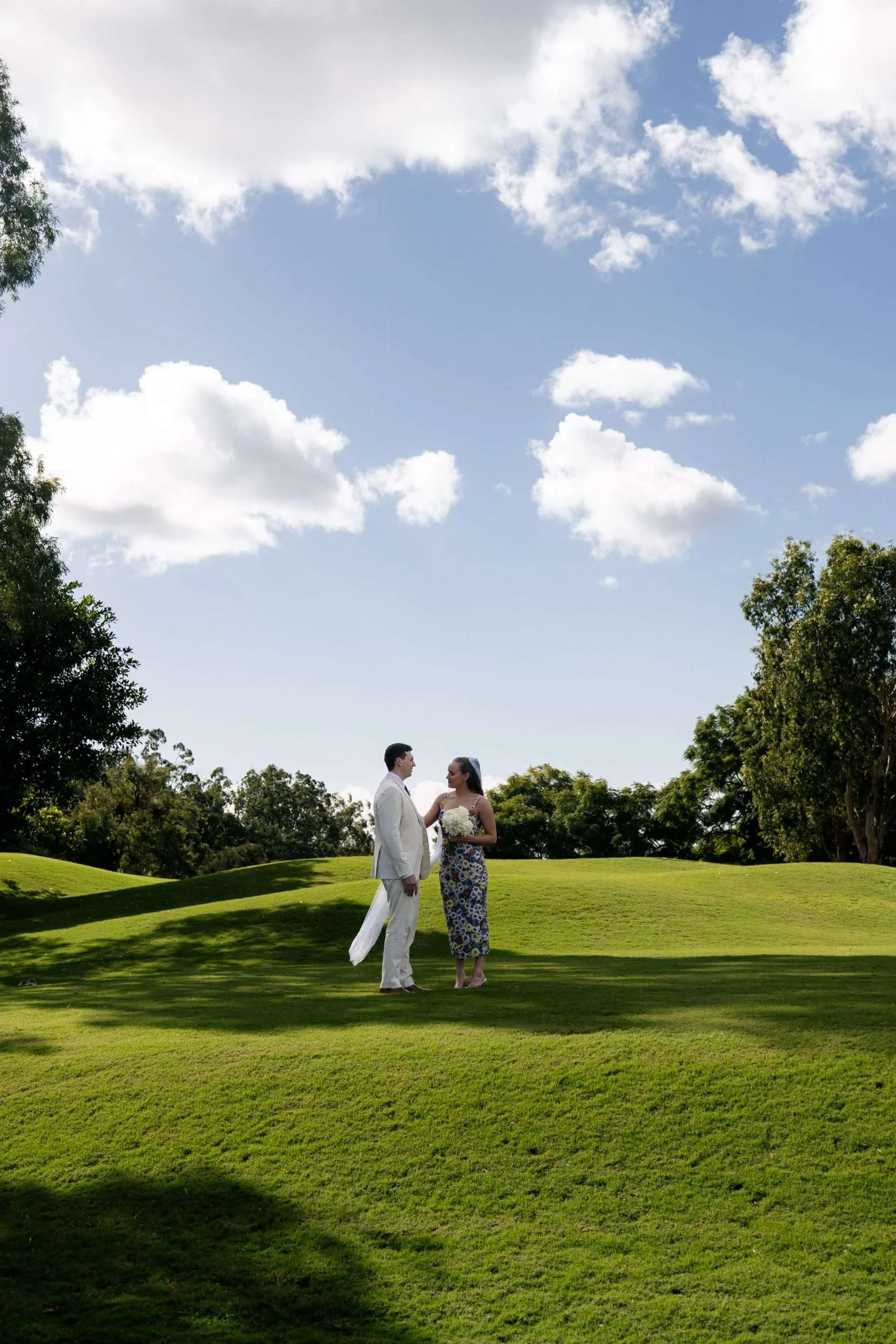 Bride and groom standing face to face, looking into each other’s eyes.