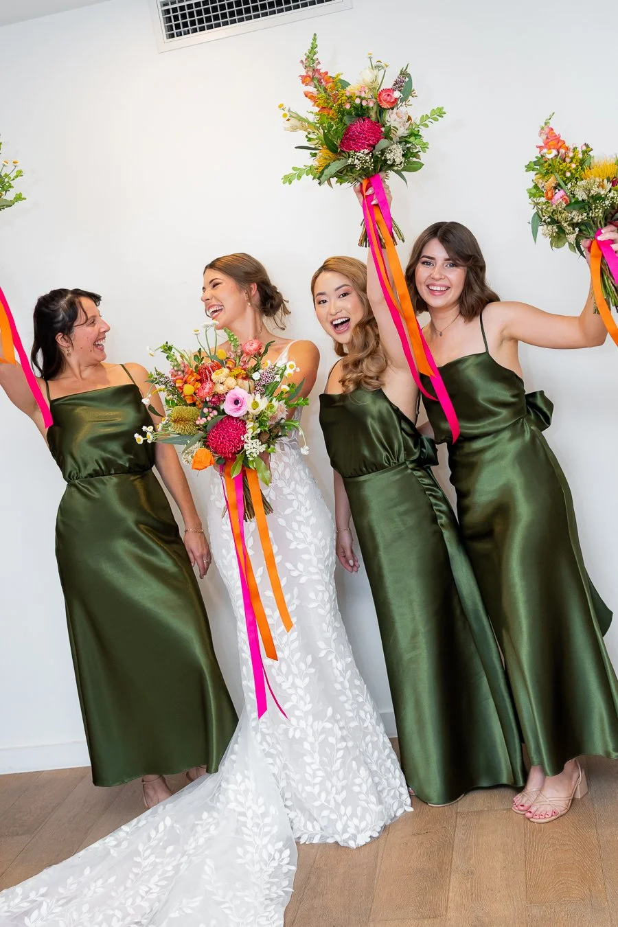 The bridesmaids raised their bouquets, and the bride held hers forward